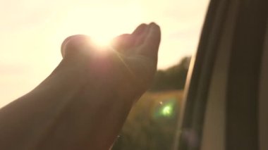 Özgür bir kadın arabayla seyahat eder. Güneşi yakalar ve elini arabanın camından çeker. Kız arabanın ön koltuğunda oturur, pencereye uzanır ve batan güneşin parıltısını yakalar. seyahat ve macera kavramı