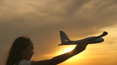 Kız pilot ve astronot olmak istiyor. Ağır çekim. Mutlu kız gün batımında oyuncak bir uçakla sahada koşuyor. Çocuklar oyuncak uçak oynuyorlar. Gençler uçmayı ve pilot olmayı hayal eder..