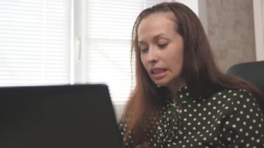 Modern taşınabilir bir cihazla çalışan serbest çalışan bir işçi. Modern iş kadını, evde dizüstü bilgisayarla çalışan girişimci. Ev ofisinden bilgisayar kullanan genç profesyonel bir kadın..