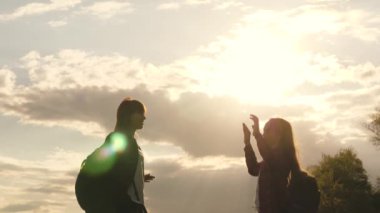 Turistler selamlar ve sevinirler. İki özgür kız, sırt çantalı gezginler, el çırpmalarıyla tepenin zirvesinde buluşuyorlar. Kadın turistlerin takım çalışması. Zorluklarla kazanma önerileri.