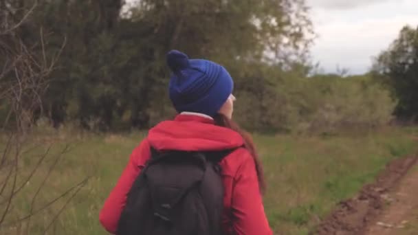 自由和健康的生活方式。健康的女孩旅行。自由的、快乐的女旅行家，背着背包在森林路上走着，挥挥手跟在我后面笑着。旅行和探险概念. — 图库视频影像