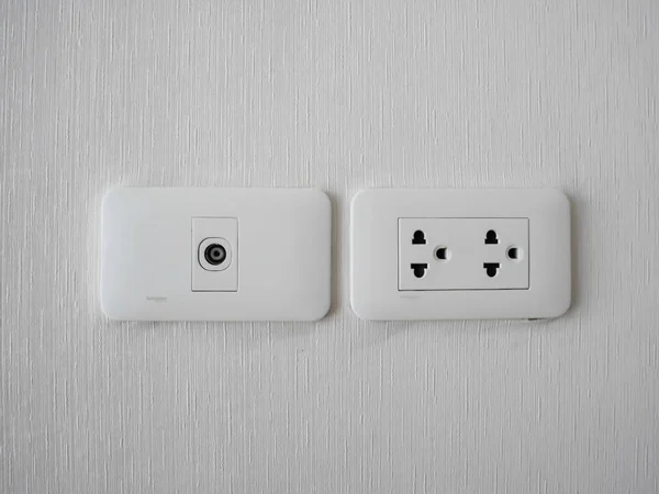 Plug Into Electricity Socket the power outlets on the wall. sockets plug outlets with 220 volts (220V) AC style. White electrical outlet on wall in the Thailand