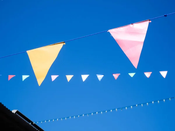 Pennant flag strings, Festival and Fair Decoration Party, Triangle flags against blue sky.