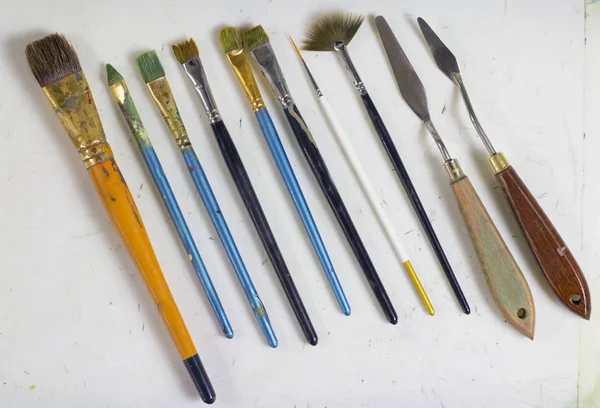 A set of old art brushes and palette knives, palette knots. The artist\'s tools. Brushes for painting. Artistic accessories, art supplies