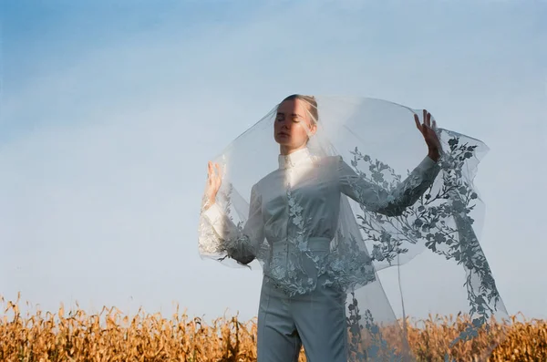 Beautiful bride in a white wedding costume. field, corn white woman boquet veil