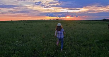 Güzel yeşil tarlada koşan bir kızın görüntüsü.