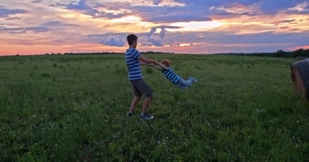 晚上父亲和儿子在美丽的绿地玩耍的场景 — 图库视频影像