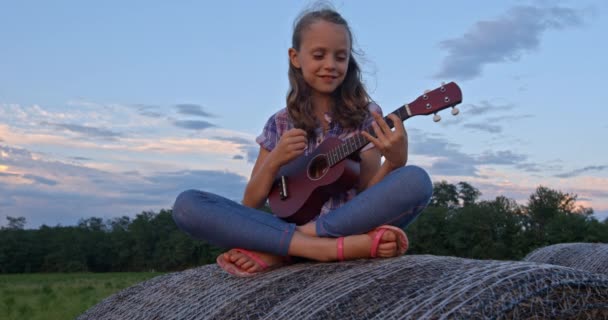 Scénický Záběry Dívky Hraje Ukulele Zatímco Sedí Seno Krásném Zeleném — Stock video