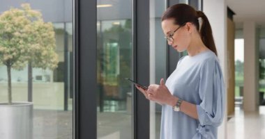 Pencereden bakarken Tablet Parşömenlerini Tutan Genç Kadın