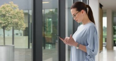 Pencereden bakarken Tablet Parşömenlerini Tutan Genç Kadın