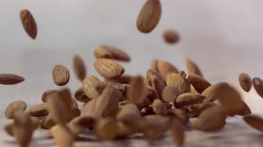 Ahşap yüzeye düşen badem fıstığı yığını, yavaş hareket