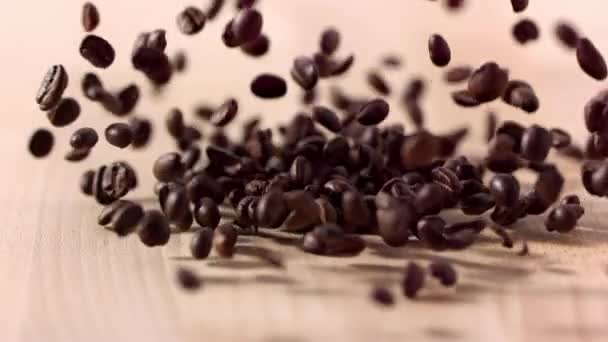 Braune Kaffeebohnen Fallen Auf Holztisch Zeitlupe — Stockvideo