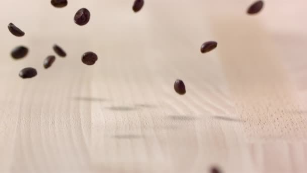 Brown Coffee Beans Falling Wooden Table Slow Motion — Stock Video