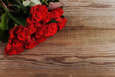 Ahşap masa üzerinde kırmızı gül buketi. Kavram kadın gün ya da St. Valentine. Kopya alanı.