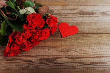 Kırmızı güller ve ahşap masa kalpler. Kavram kadın gün ya da St. Valentine. Kopya alanı.