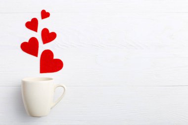 Red hearts coming out of the cup on white background. Concept of Women's Valentine's Day. Place for text, copy space.