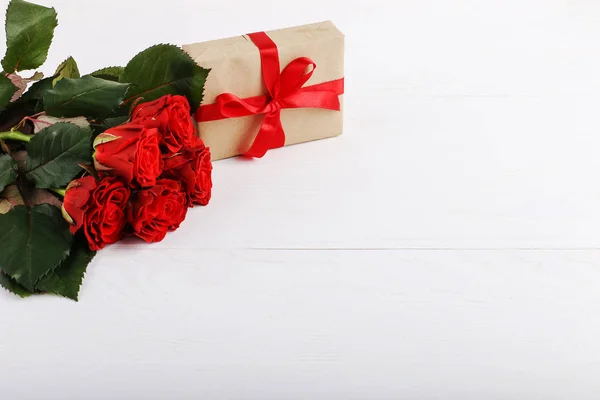 Een Boeket Van Rode Rozen Een Geschenk Witte Houten Tafel — Stockfoto