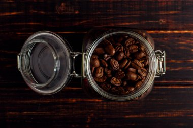 Kahve fasulye konservesi ahşap bir masa üzerinde duruyor. Metin, kopya alanı için yer.