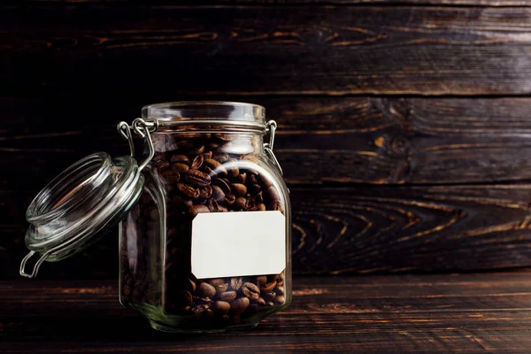 A can of coffee beans stands on a wooden table. Place for text, copy space.