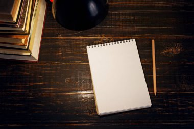 Öğretmenin masası ya da bir işçi, hangi yazı malzemeleri yalan, bir kitap, akşam lamba altında. Okul teması için metin veya arka plan için boş. Kopyalama alanı.