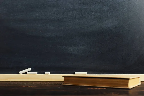 テキストや学校のテーマの背景の空白と木製のテーブルの上の黒チョーク ボード — ストック写真