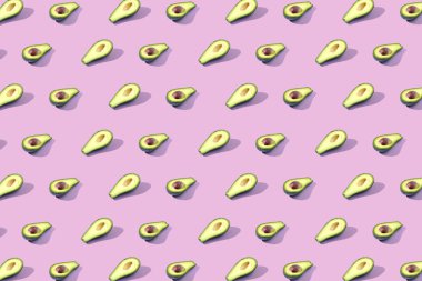 Birçok Yarım avokado, desen, afiş. Parlak arka plan, pastel pembe mor renk hasat.