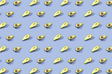 Birçok Yarım avokado, desen, afiş. Parlak arka plan, mavi menekşe pastel renk hasat.