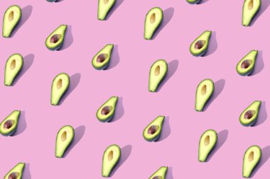 Birçok Yarım avokado, desen, afiş. Parlak arka plan, pastel pembe mor renk hasat.