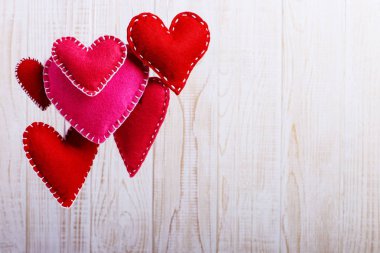 Kırmızı kalp ipe ahşap beyaz arka plan üzerinde hissetti. Tebrik kartı, kopya alanı için el yapımı boş.