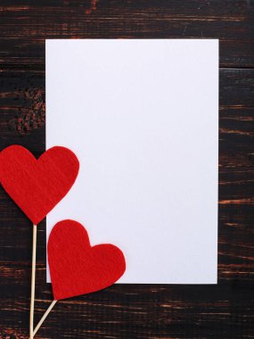 El yapımı kırmızı keçe kalp sonraki beyaz kağıt ahşap masa üzerinde. St. Valentine ve kadın gün, kopya alanı kavramı.