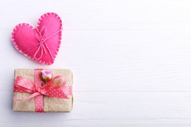 Pembe keçe kalp ve el yapımı hediyelik Beyaz ahşap masa, kavram, afiş, kopya alanı.