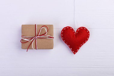 Kırmızı kalp keçe ve el yapımı, Beyaz ahşap masa, kavram, afiş, boşluk kaydedin.