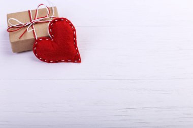 Kırmızı kalp keçe ve el yapımı, Beyaz ahşap masa, kavram, afiş, boşluk kaydedin.