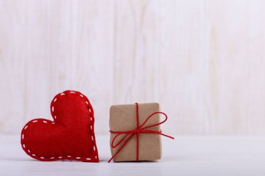 Kırmızı kalp keçe ve el yapımı, Beyaz ahşap masa, kavram, afiş, boşluk kaydedin.