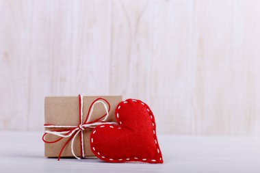 Kırmızı kalp keçe ve el yapımı, Beyaz ahşap masa, kavram, afiş, boşluk kaydedin.