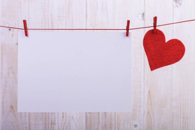 El yapımı kırmızı kalpler ve beyaz kağıt clothespins iple asılı hissettim. Kavramı, afiş, kopyalama alanı, form.
