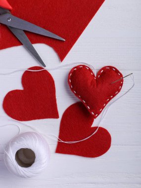 El yapımı kırmızı kalbinde yanında konu ve iğne beyaz masada hissettim. Kadınlar günü kavramı, kopya alanı.