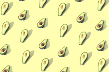 Birçok Yarım avokado, desen, banner. İşlenecek parçanın parlak arka plan, pastel sarı renk.