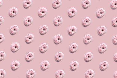 Tatlı ve lezzetli donuts renkli buzlanma ve toz, gibi parlak pastel renk arka plan üzerinde desen. Ev yapımı tatlı ve pişirme kavramı.