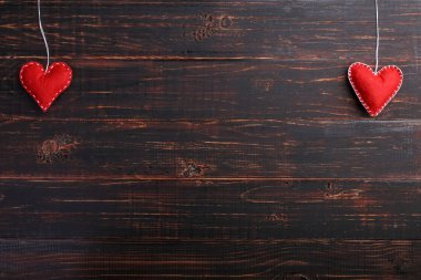 Ahşap masa, kavram, afiş, el yapımı kırmızı keçe kalpleri yer kopyalayın.
