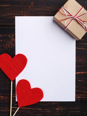 El yapımı kırmızı kalp ve hediye, sonraki beyaz kağıt, ahşap masa üzerinde hissetti. St. Valentine ve kadın gün, kopya alanı kavramı.