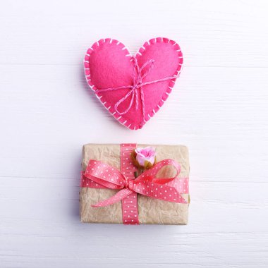 Pembe keçe kalp ve el yapımı hediyelik Beyaz ahşap masa, kavram, afiş, kopya alanı.