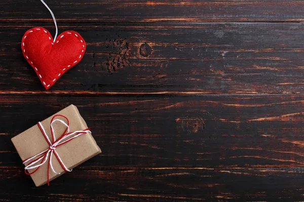 Handmade red felt heart and gift, on wooden table, Concept, banner, save space.