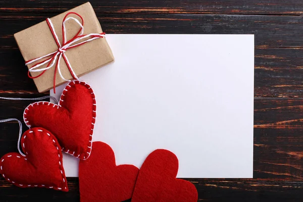 El yapımı kırmızı kalp ve hediye, sonraki beyaz kağıt, ahşap masa üzerinde hissetti. St. Valentine ve kadın gün, kopya alanı kavramı.