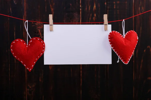 El yapımı kırmızı kalpler ve beyaz kağıt clothespins iple asılı hissettim. Kavramı, afiş, kopyalama alanı, form.