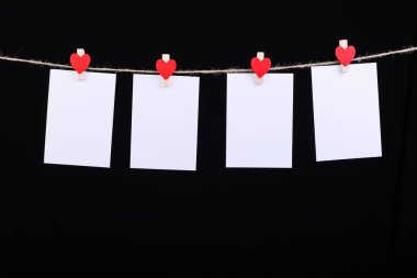 Kırmızı kalpler clothespin ip üzerinde. Tebrik kartı, kopya alanı, el yapımı boş izole siyah arka plan.
