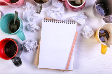 Boş kirli kahve fincanı, farklı renkler tablo ve defter mektup yazmak için. Kavram kafein uyarıcı, sorunu çözmek için enerji eksikliği. Kopya alanı.