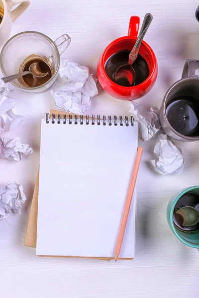 Boş kirli kahve fincanı, farklı renkler tablo ve defter mektup yazmak için. Kavram kafein uyarıcı, sorunu çözmek için enerji eksikliği. Kopya alanı.