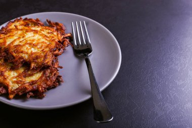 Hash brown ve ekşi krema de kızarmış karanlık bir taş zemin üzerine plaka üzerinde. Kopya alanı.
