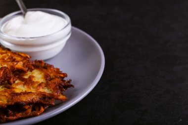 Hash brown ve ekşi krema de kızarmış karanlık bir taş zemin üzerine plaka üzerinde. Kopya alanı.